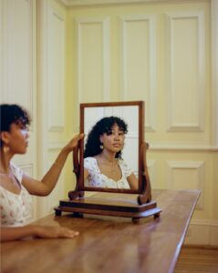 A portrait of a student looking into a mirror