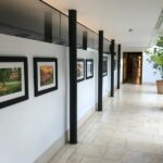 An exhibition of photography in a glass-walled corridor